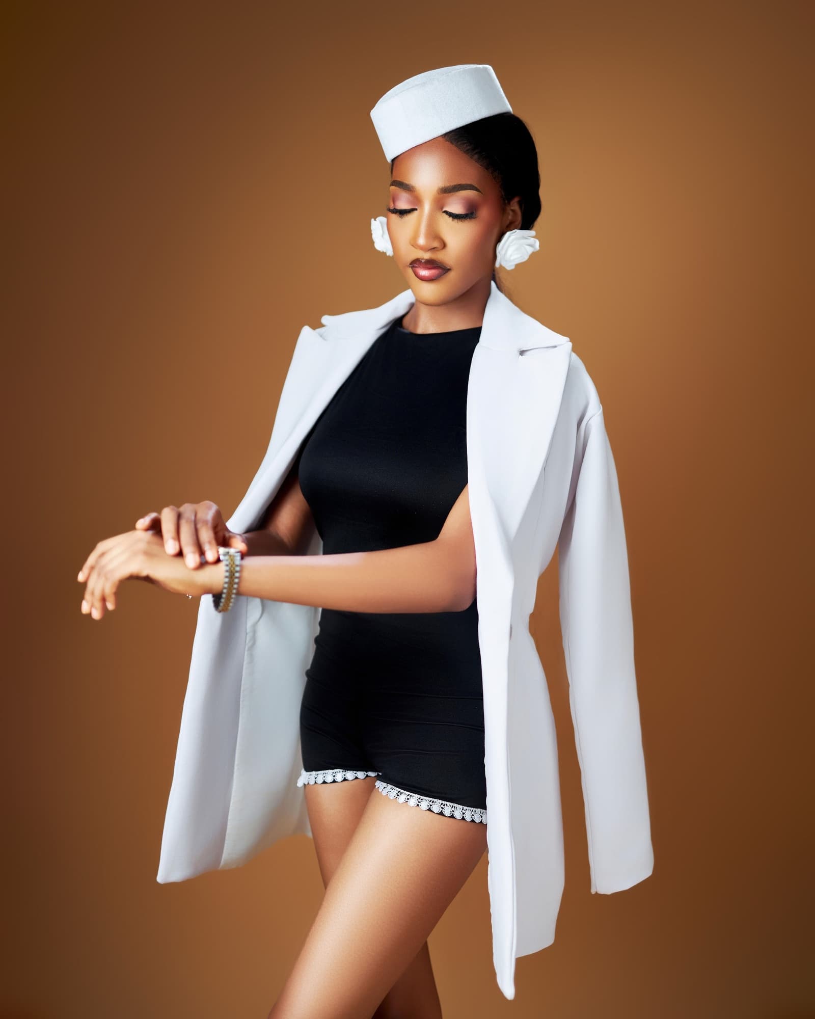 White captain's hat, black playsuit and white coat