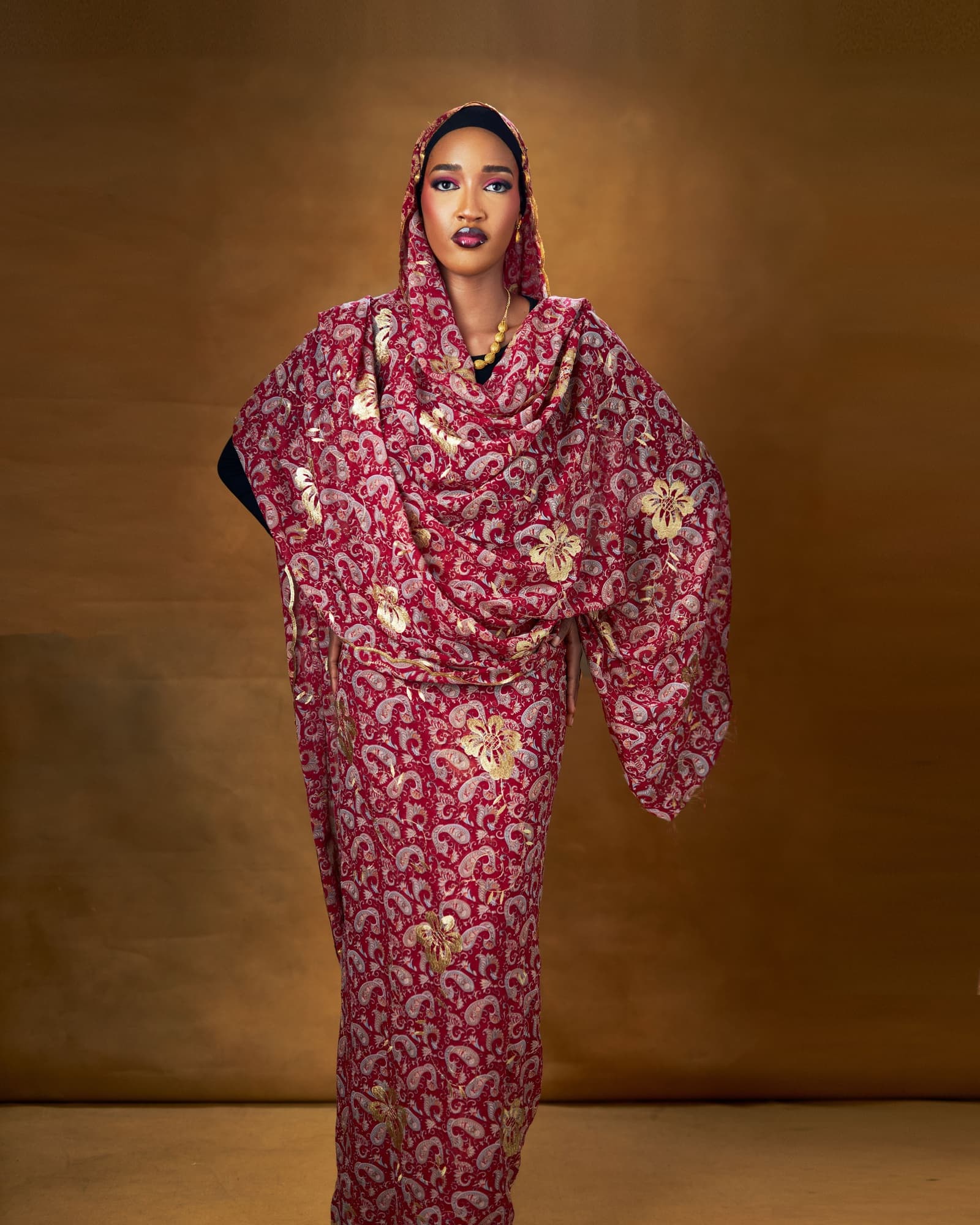 Full length in a red and gold paisley wrap