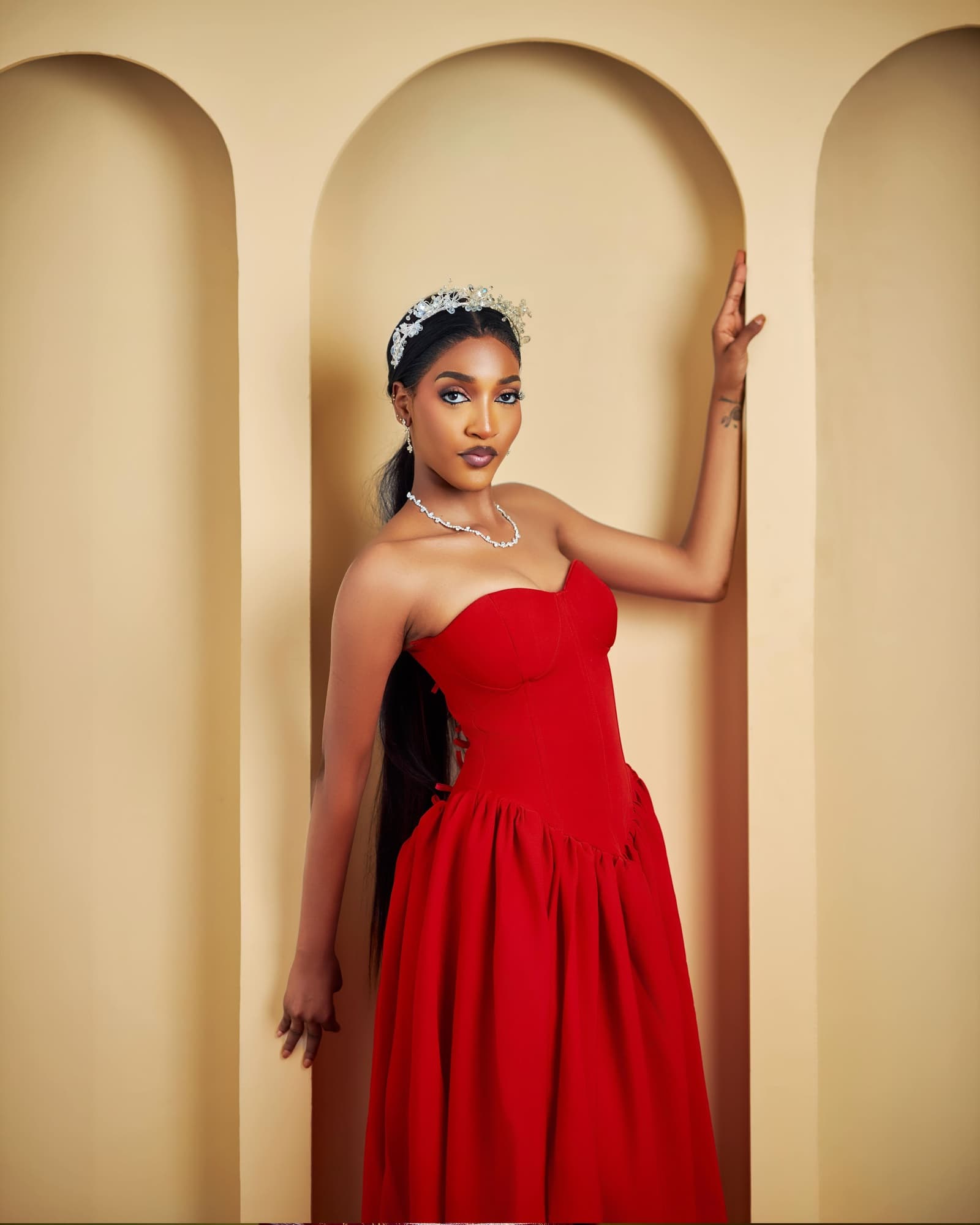 Red corset gown in a cream arched alcove