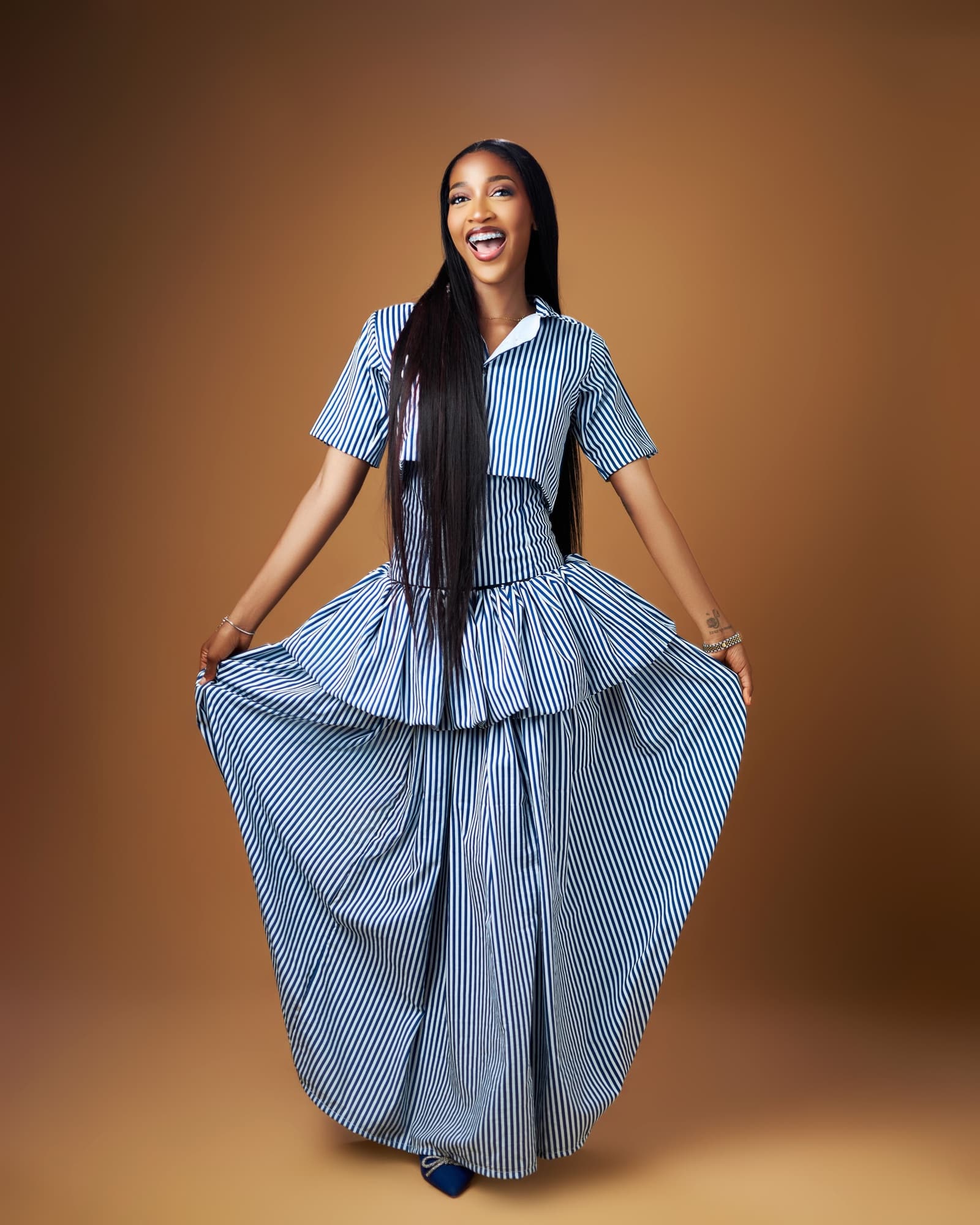 Bluethopia laughing while holding out a full striped skirt